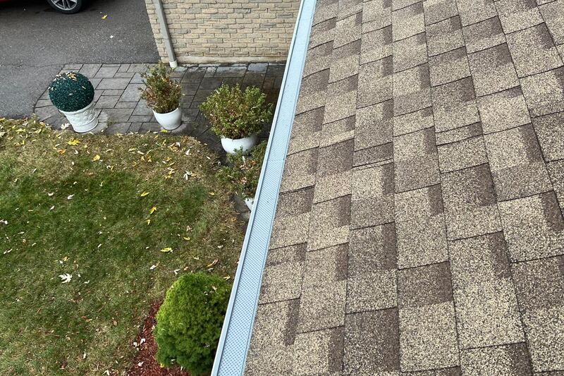 Gutter guard fitted along the eavestrough of a brick suburban home